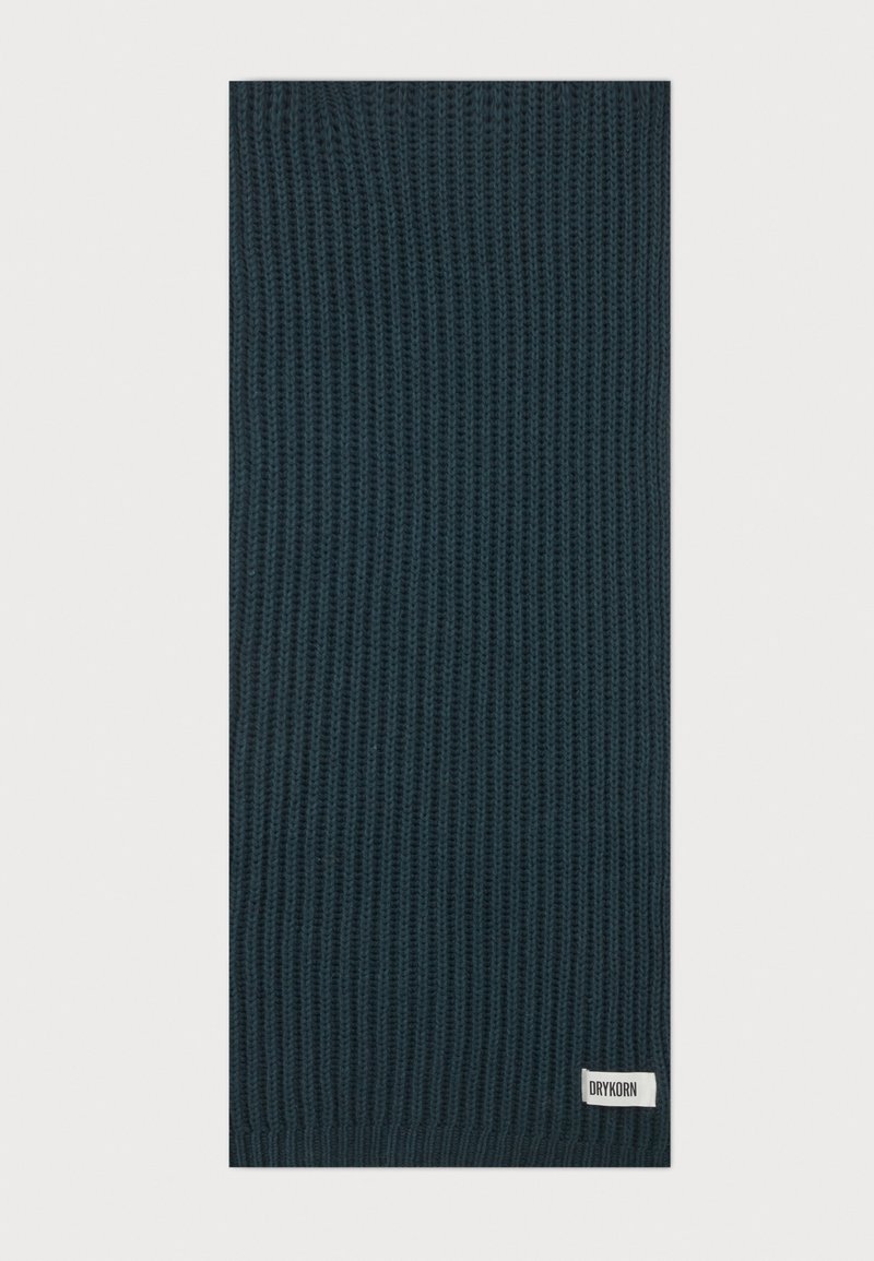 Écharpe tricotée vert foncé avec texture côtelée et une petite étiquette blanche portant la mention "DRYKORN" à une extrémité.