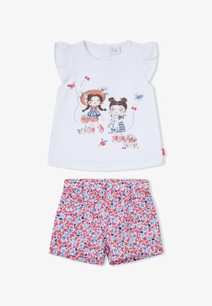 Top blanco sin mangas con volantes en los hombros con dos niñas y mariposas, combinado con unos pantalones cortos estampados de flores en rosa, azul y blanco.