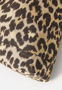 Leopard print pillow with a textured brown and beige fabric, featuring a rectangular shape and visible seam detail.