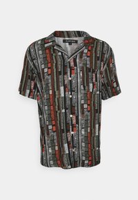 Camicia a maniche corte con bottoni nera, caratterizzata da un motivo a righe multicolore in rosso, verde e bianco, con taschino sul petto e bottoni di legno.