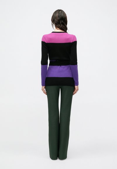 Μαύρο, μωβ και ροζ πουλόβερ με ρίγες και μακριά μανίκια, σε συνδυασμό με πράσινο παντελόνι φαρδιάς γραμμής. Λείο πλεκτό υφή, εφαρμοστή σχεδίαση.