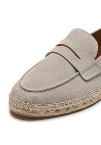 Mocassins en daim beige clair avec des coutures tonales et un accent en cuir. Dotés d'une semelle en jute tressé et d'un design à bout arrondi.