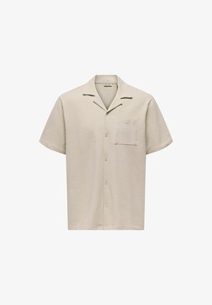 Chemise beige à manches courtes avec boutons, en tissu texturé, col campagnard et poche poitrine.