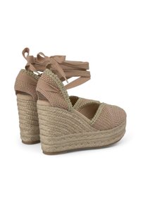 Cuñas espadrilles tejidas en color nude con suela de yute, que cuentan con una parte superior de tela texturizada, detalles trenzados y cintas ajustables en el tobillo.