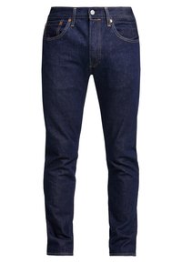 Tmavě modré slim-fit džíny s předním knoflíkem, zipem, poutky na opasek a pěti kapsami, viditelné na bílém pozadí.