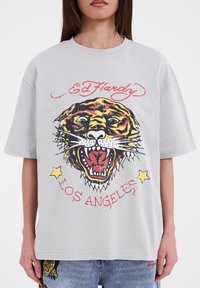 Grå T-shirt med korte ærmer, der har et stort tiger grafik med røde og gule detaljer og teksten "Los Angeles" i rød nedenfor designet.
