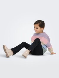 Knit sweater with pastel stripes; black pants; beige ankle boots with textured surface and side zipper. Child seated, smiling.