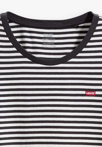 Svart og hvit horisontalt stripete genser med rund hals og en liten rød Levi's logo-patch på brystet.