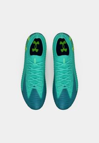 Τυρκουάζ αθλητικά παπούτσια με γκριάντ στη μύτη προς σκούρο μπλε, υφασμάτινη επιφάνεια και πράσινες λεπτομέρειες στο λογότυπο και τα κορδόνια.