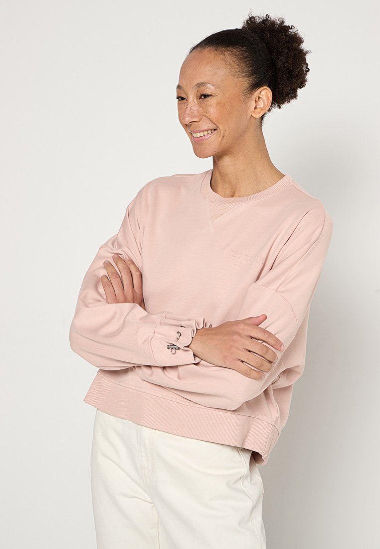 Helles rosa Sweatshirt mit langen Ärmeln, gerippten Bündchen und einem verkürzten Saum. Besticktes Logodetail auf der Brust. Weiche Stofftextur.