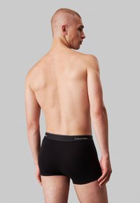 Boxer briefs de algodón negro con una amplia cintura elástica que presenta el logo de Calvin Klein. El ajuste es ceñido y tiene una textura suave.