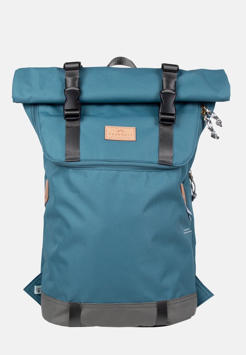 Turkusowy plecak z odchylaną górą, czarne paski i elementy metalowe, skórzana etykieta, szary spód oraz boczne kieszenie dla dodatkowej funkcjonalności.