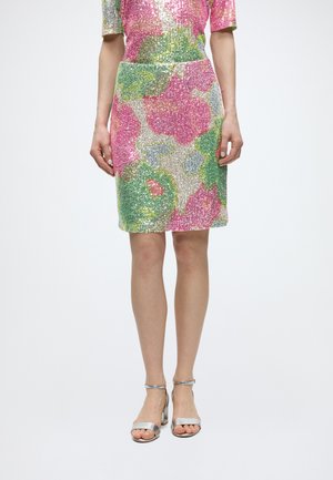 Knelengdeskjørt med høyt liv i rosa, grønt og sølvfarget paljettblomstermønster, brukt med sølv åpne tå hæler.