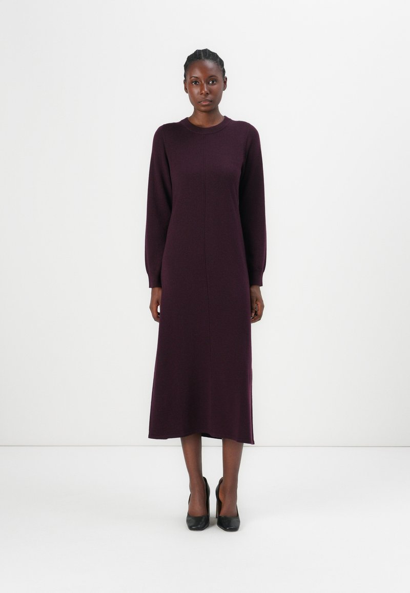 Robe à manches longues, longueur genoux en tissu tricoté bordeaux profond. Dispose d'un col rond, de détails de couture avant subtils et d'une coupe décontractée.