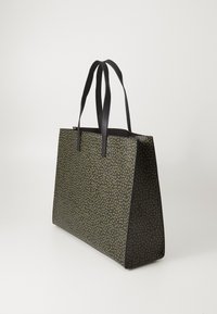 Getextureerde zwarte totebag met een groen bladdessin, hoge rechthoekige vorm en twee zwarte handvatten. Gemaakt van synthetisch materiaal.