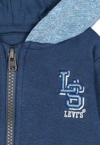 Felpa con zip blu navy in misto cotone, con fodera del cappuccio a motivo denim e logo Levi's ricamato in azzurro.