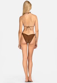 Brązowy bikini z dekoltem na halter. Posiada wiązania na szyi oraz z boku. Lekko teksturowany materiał, dolna część o niskim stanie z minimalnym zakryciem.