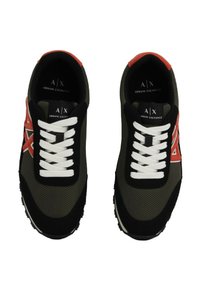 Une paire de baskets Armani Exchange noires et grises avec des lacets blancs et des accents de logo rouges, vue de dessus.