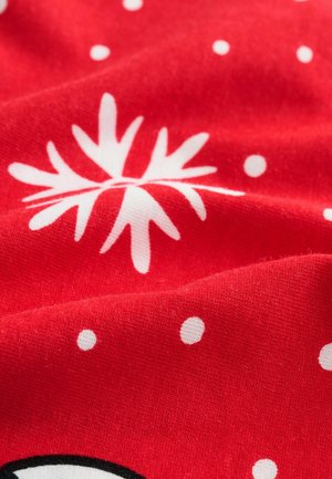 Tissu rouge avec des motifs de flocons de neige blancs et de pois. La texture semble douce et légèrement texturée, avec des motifs clairs et contrastés.