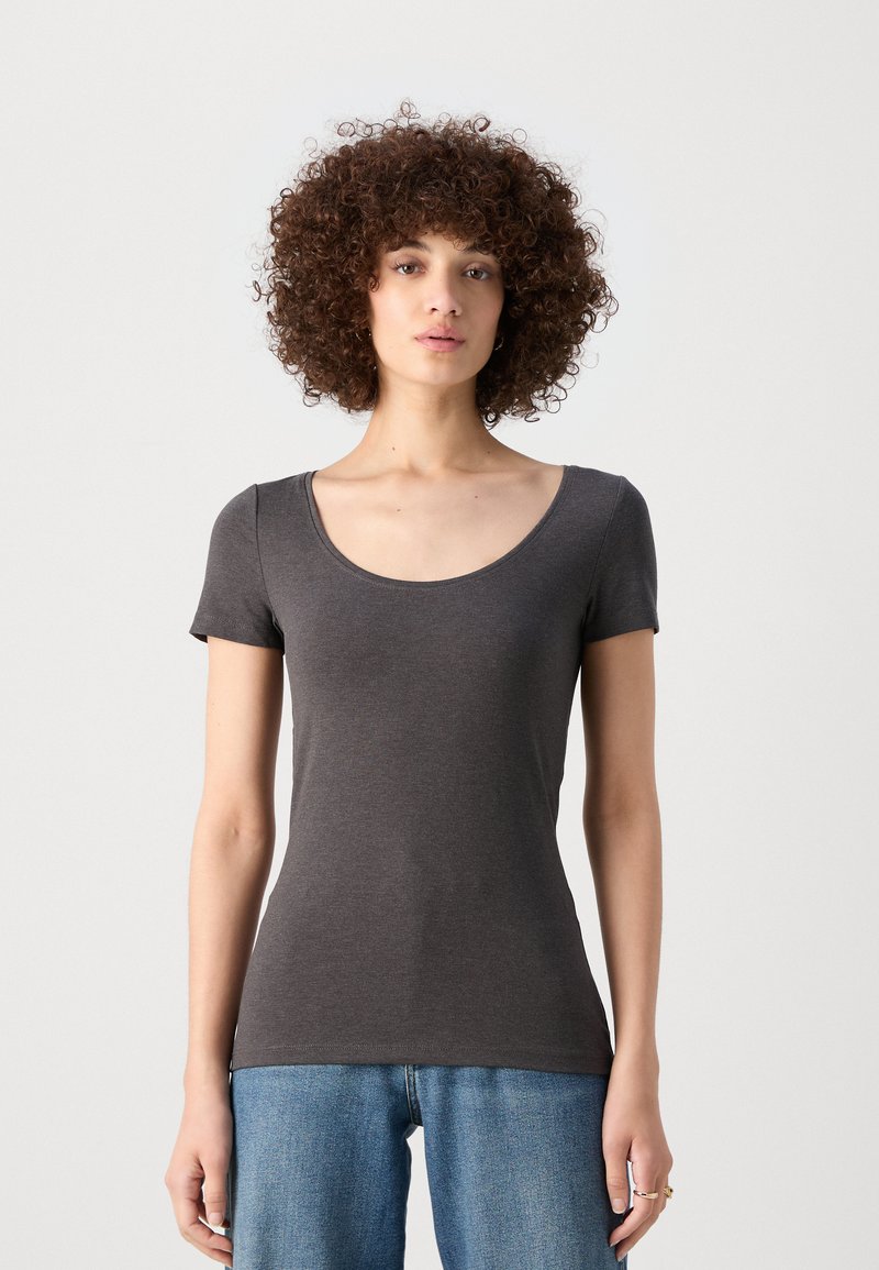 T-shirt gris à manches courtes avec un décolleté en forme de scoop, au design ajusté, fabriqué dans un matériau lisse. Associé à un jean en denim bleu taille haute.