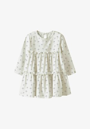 Vestido blanco de manga larga con pequeño estampado floral azul, volantes escalonados en el dobladillo y abertura en forma de ojo de cerradura en la espalda. Tela suave con textura lisa.