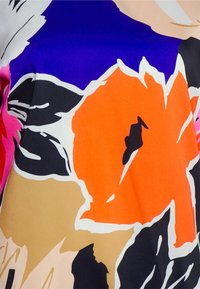 Kolorowa tkanina kwiatowa z wyrazistymi kolorami, takimi jak pomarańczowy, różowy, czarny i beżowy. Gładka tekstura z abstrakcyjnymi wzorami kwiatów i kontrastującymi elementami.