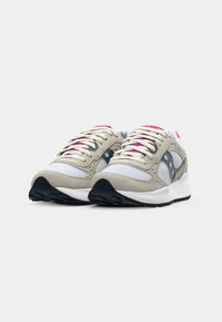 Baskets de course beige et grises avec un dessus en daim texturé et mesh, accents rose et gris, lacets plats et semelle en caoutchouc noire.