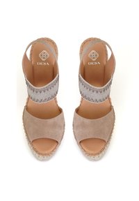Beige suède espadrillesandalen met open neuzen, elastische band en geweven juten zolen; zachte textuur met decoratieve stikselaccenten.