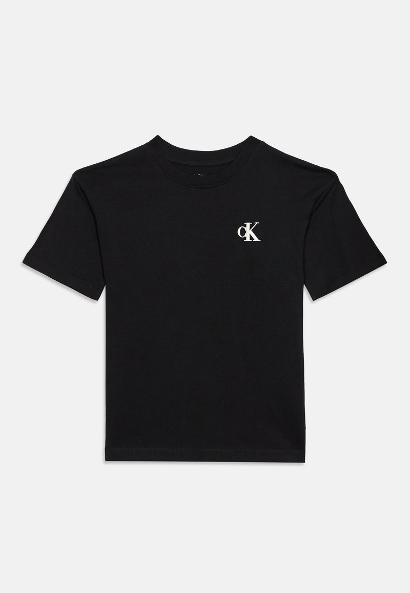 T-shirt noir à manches courtes et col rond, avec un petit logo CK blanc sur la poitrine, présenté sur un fond uni clair.