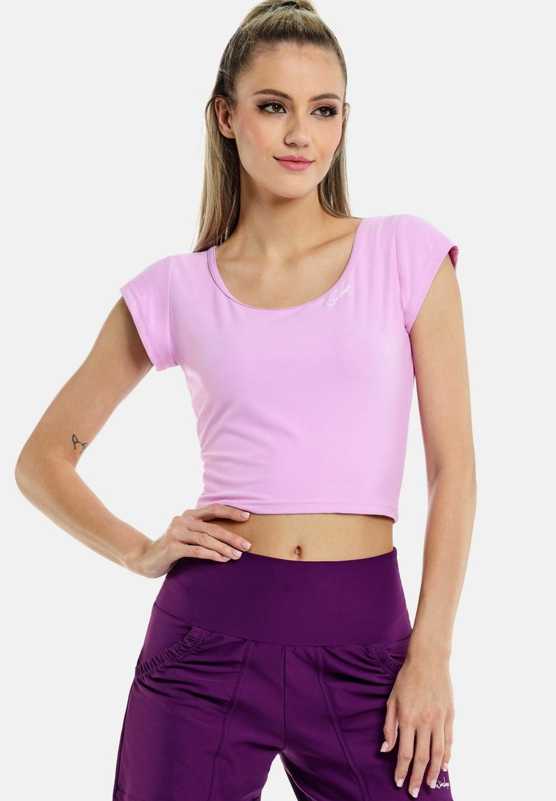 Top corto rosa chiaro con maniche corte, realizzato in un tessuto elasticizzato. Presenta un colletto rotondo e un accento logo sottile.
