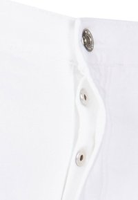 Tela de algodón blanca con una fila de botones de metal plateado en la cintura, con una textura suave y un diseño limpio.