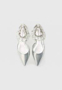 Scarpe argento a punta con finitura lucida. Decorazioni in bead trasparenti sul tallone e un interno testurizzato e lucido.