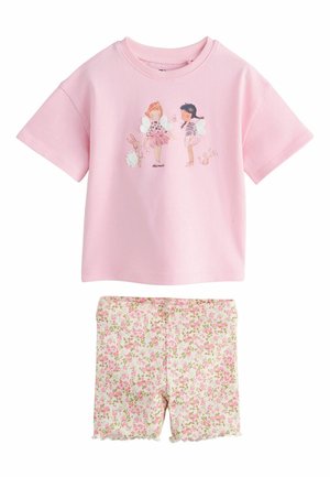 Ružové tričko s krátkym rukávom s potlačou víly a zvierat, kombinované s bielymi rebrovanými šortkami s ružovým kvetinovým vzorom a vlnitými lemami.