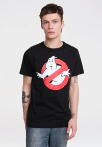 Black cotton t-shirt featuring a graphic of a white ghost inside a red no symbol. Round neckline and short sleeves. Casual fit.