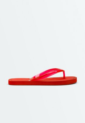 Enkel rød flip-flop sandal med flad sål og blanke gennemsigtige røde stropper på en ensfarvet hvid baggrund.