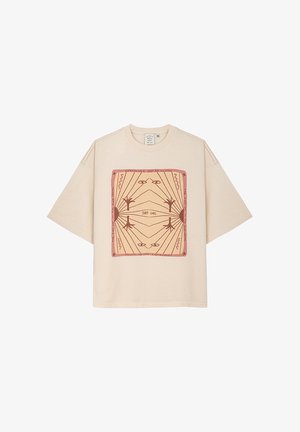 Beiges Übergrößen-T-Shirt aus Baumwolle mit einem quadratischen grafischen Design, das geometrische Linien und Text in rötlich-braunen Tönen zeigt.