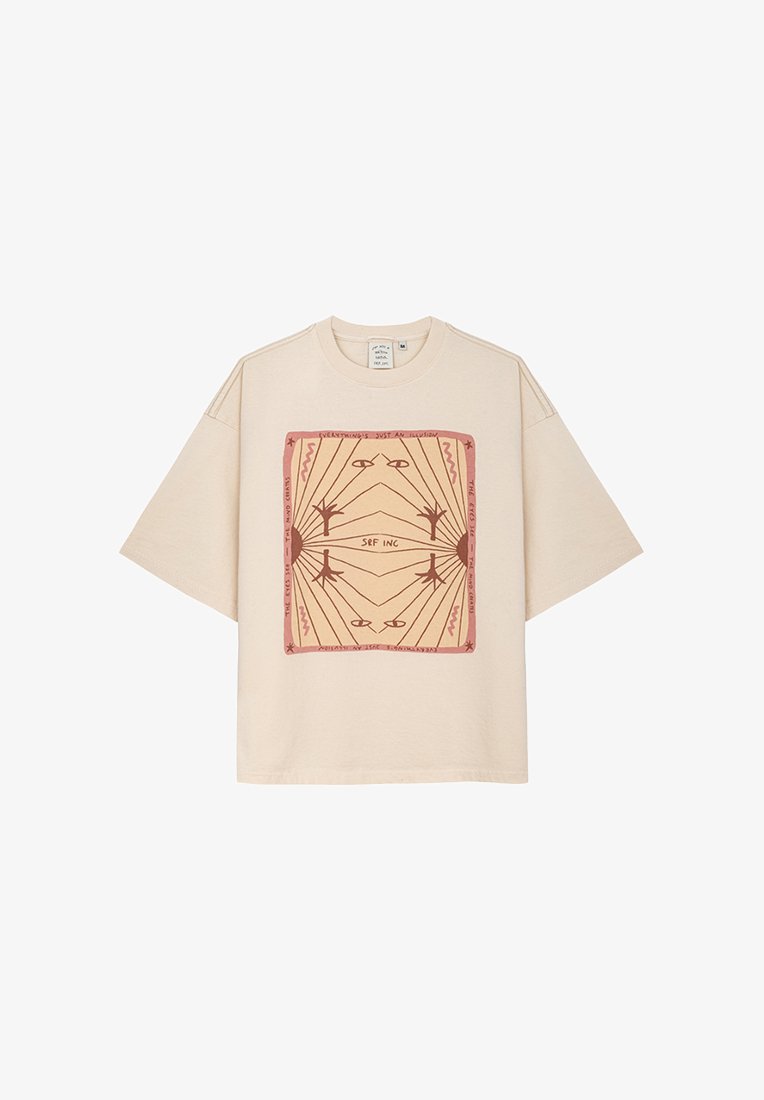 Beżowa, oversize'owa koszulka z bawełny z kwadratowym graficznym wzorem, przedstawiającym geometryczne linie i tekst w odcieniach czerwono-brązowych.