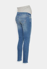 Calças de maternidade em denim azul de lavagem média. Apresenta uma cintura em tecido cinza elástico, pernas justas e acabamentos desgastados com bordas desfiadas.