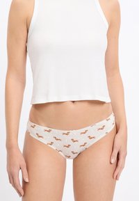 Katoenen hipsteronderbroekjes met een lichtbeige basis, voorzien van een herhalend teckelprintje, een decoratief strikje en kanten rand langs de tailleband.