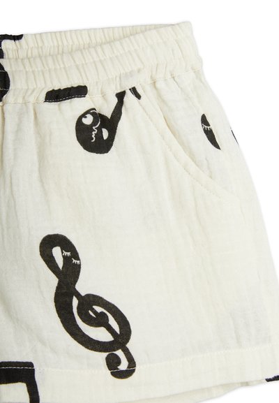 Light cream shorts with black musical note pattern, featuring an elastic waistband and side pockets, made from soft, breathable fabric.