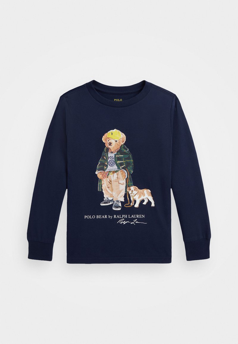 T-shirt à manches longues bleu marine avec un graphique d'un ours en veste, portant une casquette jaune et accompagné d'un chien. Tissu en coton doux avec des poignets côtelés.
