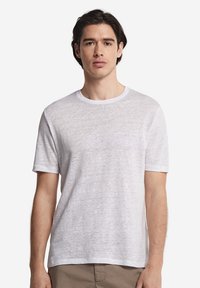 Vit kortärmad T-shirt med rund halsringning, tillverkad av en texturerad, lättviktsmaterial. Skuren i en avslappnad passform för komfort.
