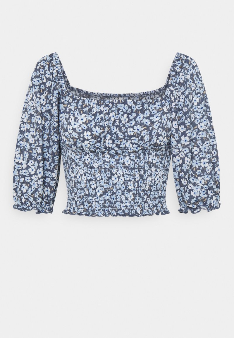Top floral con escote cuadrado, mangas abullonadas, patrón de flores azules y blancas sobre un fondo oscuro, fruncido texturizado en la cintura.