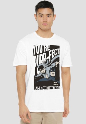 Young man wearing white T-shirt with Batman and Catwoman illustration and text "You're Purr-fect, I am not kitten you."