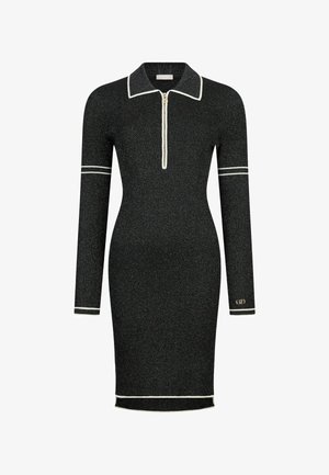 Musta ribattata neulemekko pitkillä hihoilla, vetoketjukauluksella ja kontrastivalkoisilla yksityiskohdilla. Kapealinjainen, polvipitkä malli logopainatuksella.