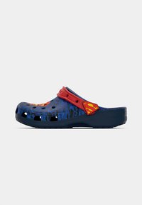 Blue plastic clogs featuring a red strap and Superman logo, with cutouts for ventilation and a textured sole for grip.