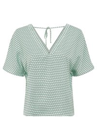 Blusa verde chiaro a maniche corte con motivo geometrico a esagoni neri, scollatura a V e un cordoncino annodato nella parte posteriore del collo.