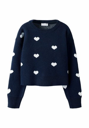 Pull cropped marine en tissu tricoté, avec des motifs de cœurs blancs sur l'ensemble, doté d'un col rond côtelé et de poignets côtelés.