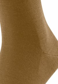 Zbliżenie gładkiej, teksturowanej brązowej skarpetki, podkreślające szczegóły tkaniny i ściegów.