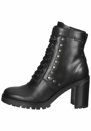 Bottine en cuir noir avec un talon haut épais, un avant à lacets et des clous métalliques sur le côté. Semelle robuste pour une bonne adhérence.
